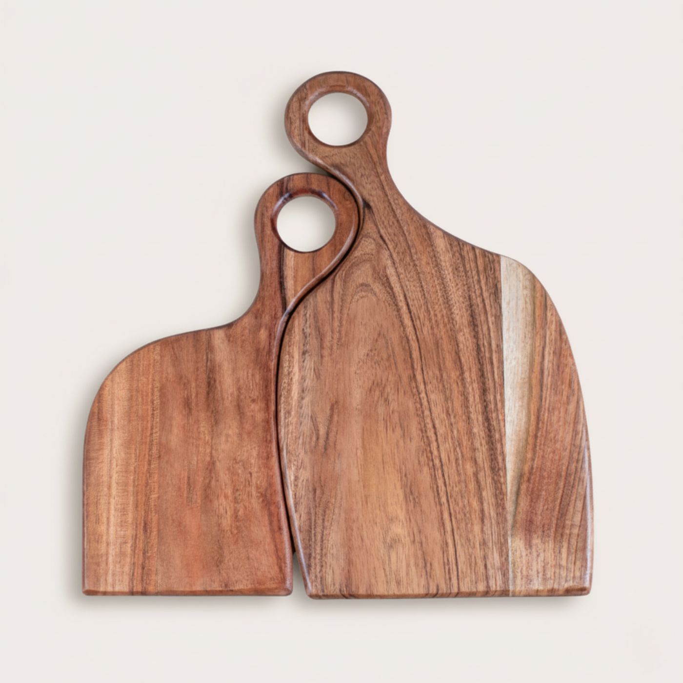 Two wooden cutting boards with handles on a light beige background