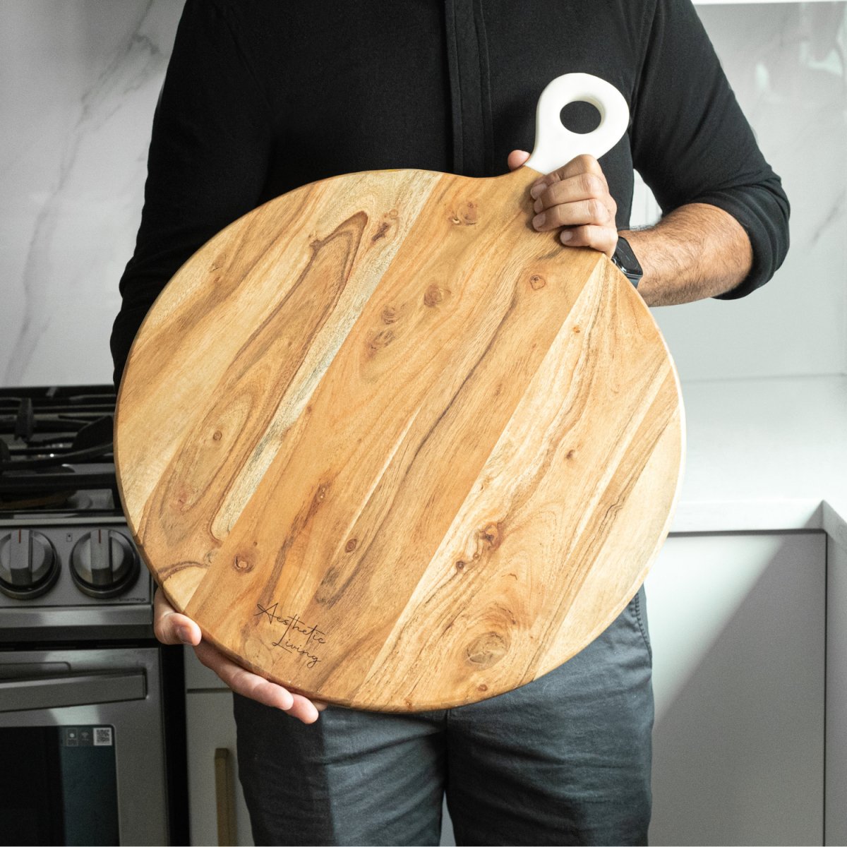 Pizza Peel Shaped Round Pizza Paddle Charcuterie Board with White Enamel Handles full image with person holding board- Aesthetic Living